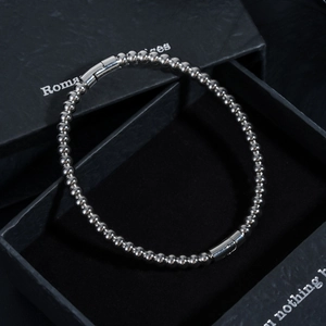 Macro shot of silver beaded bracelet with cylindrical clasp in a black jewelry box
