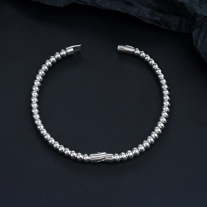 Detailed macro view of polished silver ball chain bracelet with mechanical clasp closure