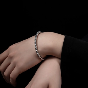 Detailed close-up of a silver beaded stainless steel bracelet with a secure clasp