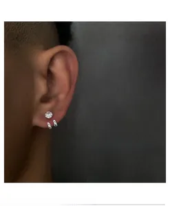 Nahaufnahme von minimalistischem Silber-Zirkonia-Stecker und Creolen am Männerohr