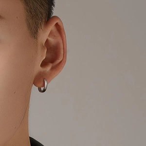 Gros plan d'une boucle d'oreille anneau argentée minimaliste au fini mat pour homme