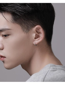 Gros plan d'une boucle d'oreille anneau argentée pour homme portée par un mannequin