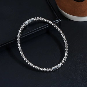Close-up of a minimalist beaded stainless steel bracelet with sleek cylindrical clasps