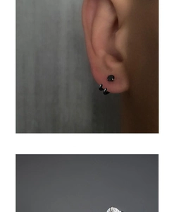Detail von schwarzem Zirkon-Stecker und Doppelspiral-Ohrring mit schickem Metallfinish
