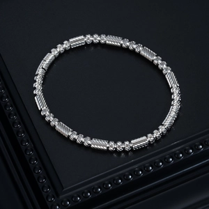 Vue détaillée du bracelet en perles d'acier argenté avec maillons cylindriques gravés