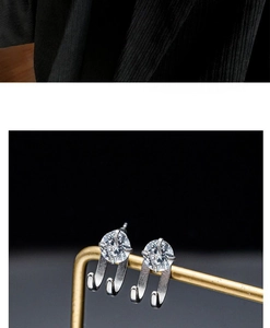 Nahaufnahme von Zirkonia-Ohrsteckern in Silber mit einzigartigem Doppelhakendesign am Ständer