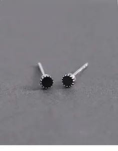 Macro detail of geometric dot stud earrings with black stone and S925 silver finish