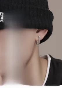 Dettaglio orecchino a perno in argento sterling S925 con lunga catena pendente da uomo
