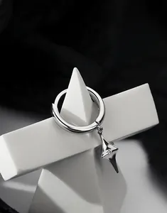 Dettaglio orecchino a cerchio argento con ciondolo a stella e zircone su base geometrica