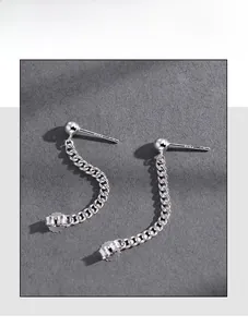 Dettaglio degli orecchini a catena cubana in argento S925 su sfondo grigio opaco moderno