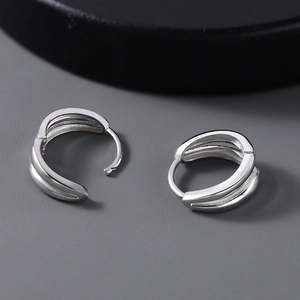 Macro view of triple-layered 925 sterling silver hoop earrings with a polished finish