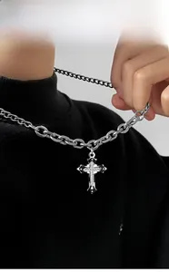 Vista dettagliata della catena d'argento spessa e del ciondolo a croce con diamanti