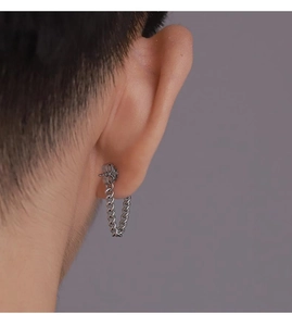 Primo piano di un orecchino a catena in argento minimalista indossato da un uomo