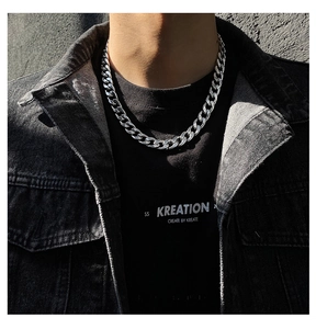 Close-up of a chunky silver Cuban link necklace on a model for a bold street hip-hop look