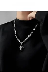 Vista dettagliata del ciondolo a croce d'argento con diamanti su catena a maglia cubana