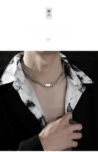 Macro detail of silver Cuban chain necklace with a polished rectangular metal plate pendant