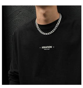 Close-up of silver metal curb chain necklace on model with streetwear aesthetic