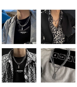 Detail of layered silver Cuban chain necklace with rectangular textured pendant