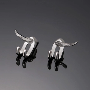 Gros plan sur les clous d'oreilles punk argentés avec base à double broche de style industriel