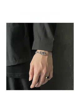 Dettaglio ravvicinato di un bracciale a catena argento con un ciondolo smiley giallo smaltato