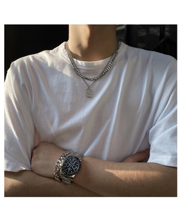 Detail of silver layering necklaces and cuban link bracelet on a male model