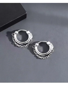 Detail of silver hoop earrings with industrial chain link design on dark gray backdrop