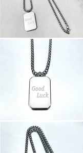 Detail des silbernen Rechteckanhängers mit Good Luck Gravur und ineinandergreifender Kette