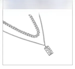 Macro shot of silver dual-layer Cuban chain necklace with a vintage Venus coin pendant