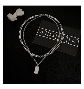 Detail of double-layer silver Cuban necklace with rectangular portrait pendant on black leather