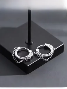 Detail view of silver metal hoop earrings with elegant dangling dual chains on black base
