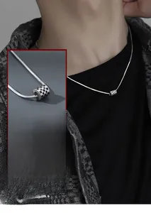 Detailed view of men's checkerboard cylinder pendant on a sleek silver snake chain