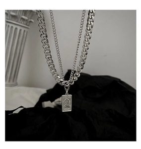 Close-up of double-layered silver Venus coin necklace on a white Roman column