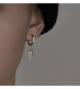 Close-up of silver cone drop earrings featuring vintage textured geometric pendants