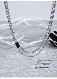 Détail du collier en acier titane avec pendentif rectangulaire noir sur décor de verre