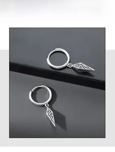 Detailed close-up of retro silver hoop earrings with geometric textured cone pendants