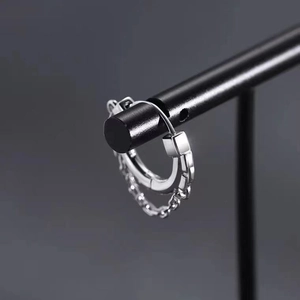 Modern silver hoop earring with chain and geometric square pendant on a stand