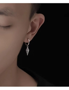 Macro detail of men's silver hoop earring with engraved geometric cone pendant