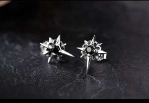 Macro shot of silver North Star stud earring with polished black zircon stone center