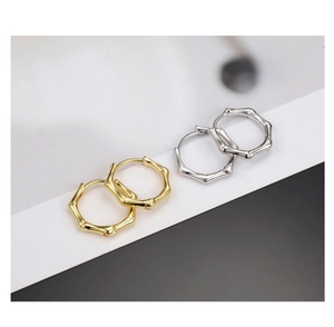 Détails de boucles d'oreilles créoles à texture bambou en finitions or et argent poli