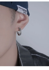 Gros plan d'une boucle d'oreille chaîne cubaine en argent pour homme portée par un mannequin