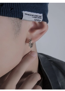 Boucle d'oreille créole argentée avec texture de chaîne portée par un mannequin