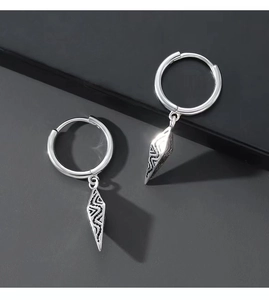 Macro detail of silver cone earrings featuring intricate geometric textured engravings
