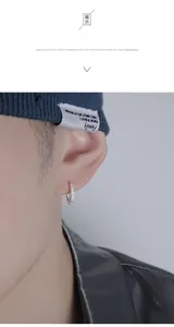 Gros plan d'une boucle d'oreille anneau argentée pour homme sertie de zircons blancs