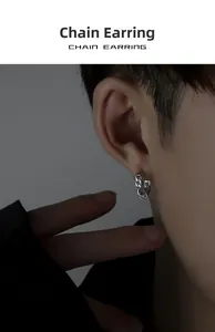 Close-up of silver Cuban chain hoop earring with ring pendant worn by male model
