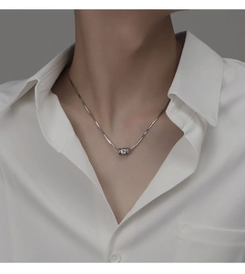 Détail du collier chaîne serpent argentée avec pendentif cylindre gravé rotatif homme