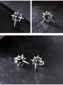Detailed view of silver star stud earrings with black zircon center in punk style