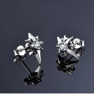 Macro shot of silver North Star stud earrings with sparkling round zircon stone