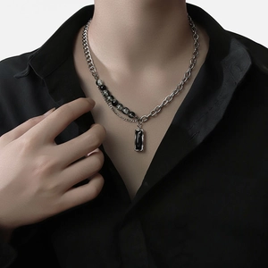 Collier pour homme avec perles noires et pendentif rectangulaire sur un mannequin