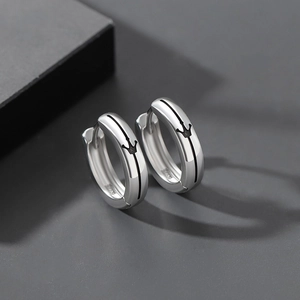 Makroaufnahme von S925-Silberohrringen mit schwarzen Kronengravuren und poliertem Finish