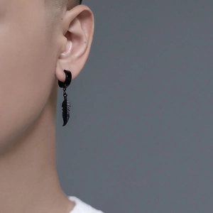 Détail d'un clip d'oreille noir en acier titane avec un pendentif en forme de plume